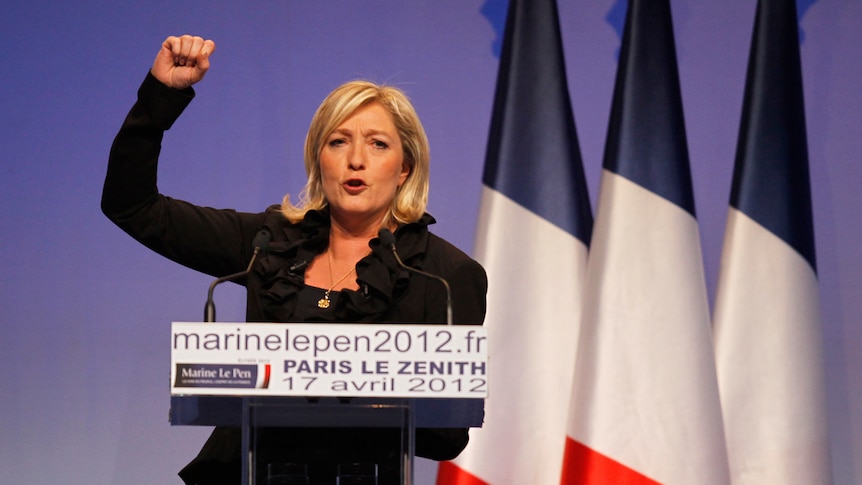 Marine Le Pen pumps her fist at a campaign rally