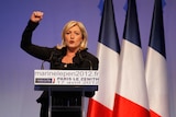 Marine Le Pen pumps her fist at a campaign rally