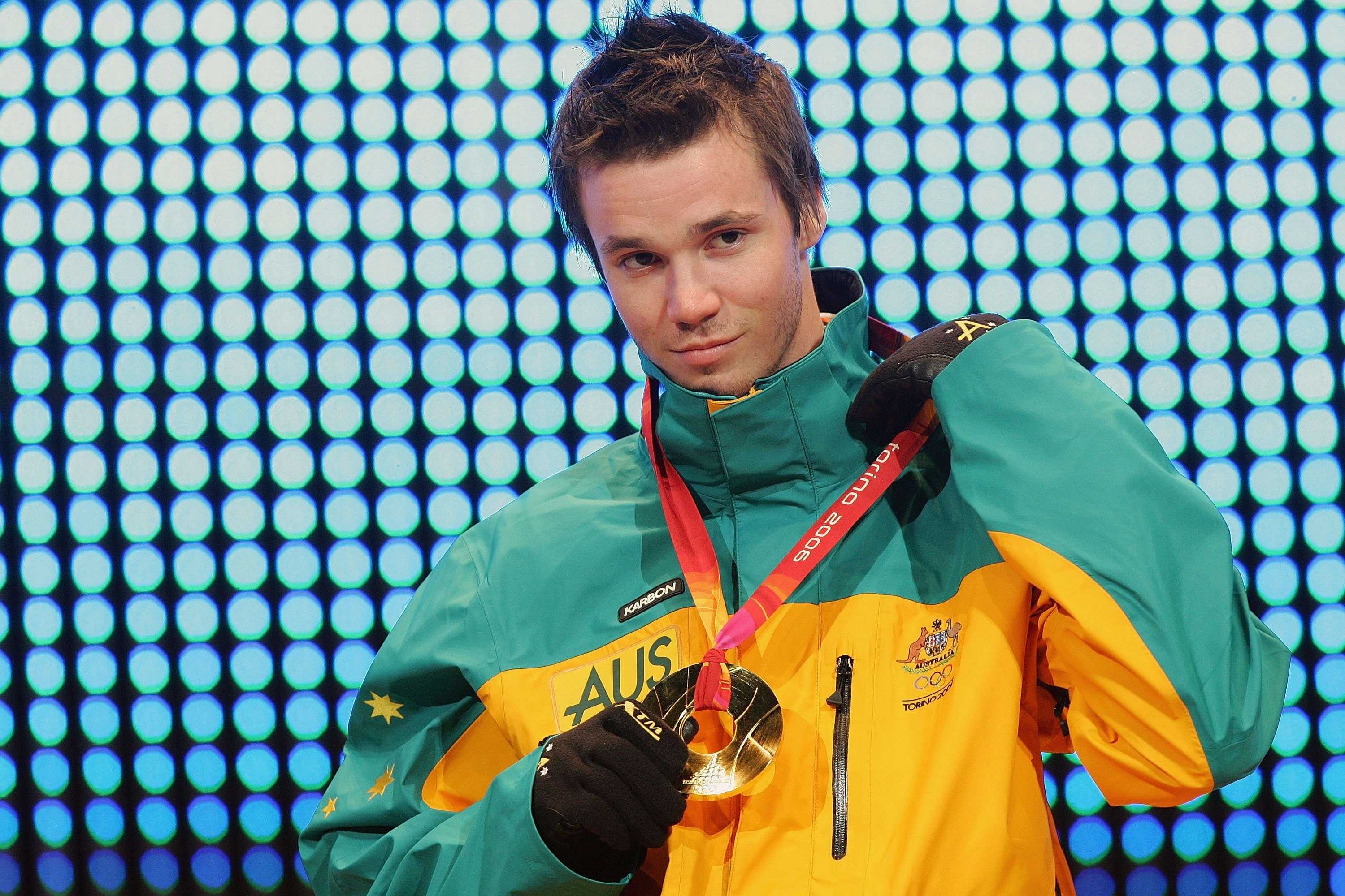 A young man in a parka with a gold medal around his neck.
