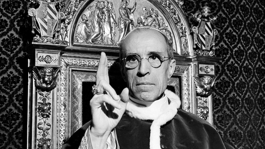Pope Pius XII raises his right hand in a papal blessing at the Vatican.