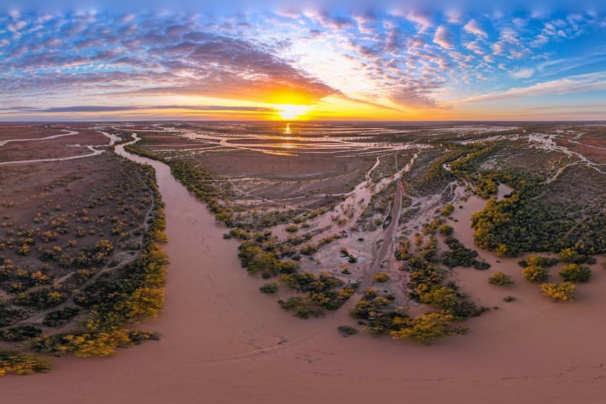 An aerial view as the sun rises over two massive rivers that wind through Queensland's Channel Country.