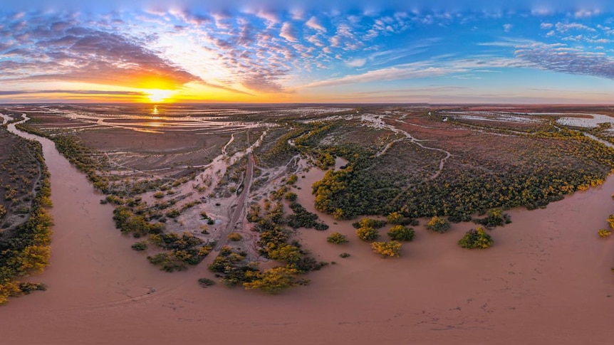 An aerial view as the sun rises over two massive rivers that wind through Queensland's Channel Country.