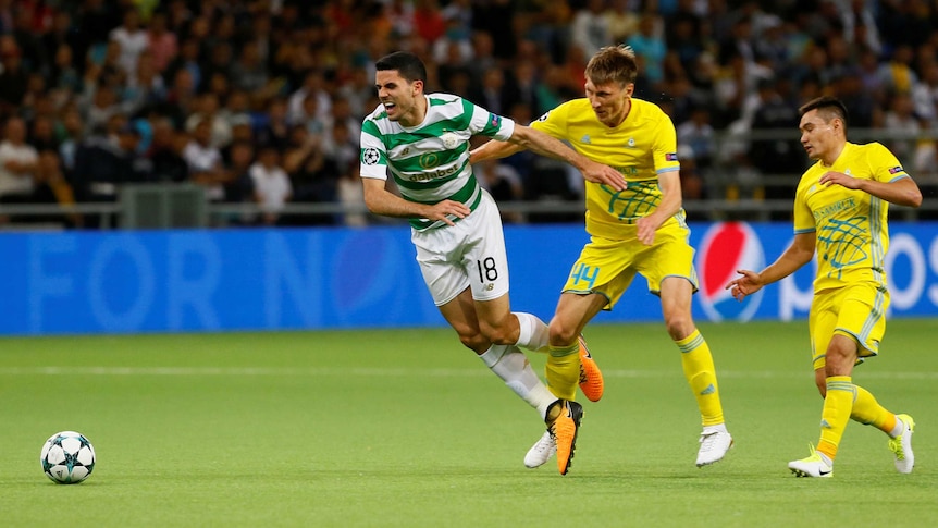 Tom Rogic chases the ball for Celtic while under defensive pressure from FC Astana.