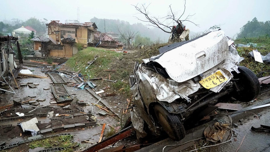 A damaged car lies on the ground following a strong wind in Ichihara, Chiba, near Tokyo.