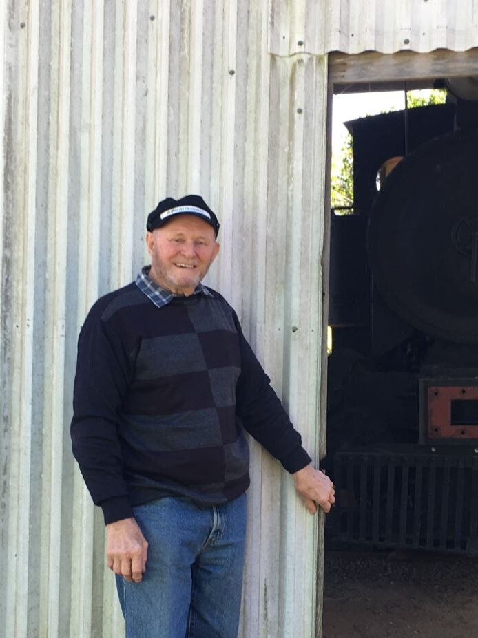 A small locomotive under a shed on a rural property, with Noel Williams.