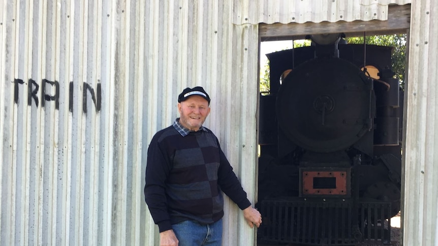 A small locomotive under a shed on a rural property, with Noel Williams