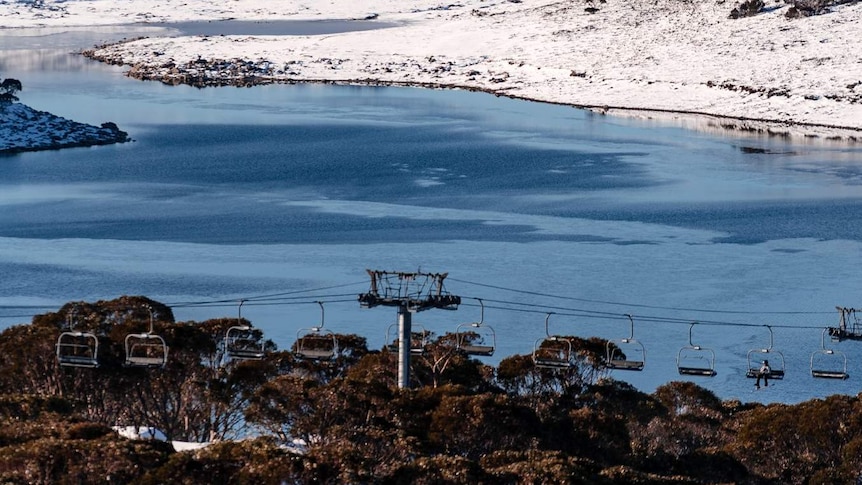 Falls Creek with some snow, a body of water and some chairlifts