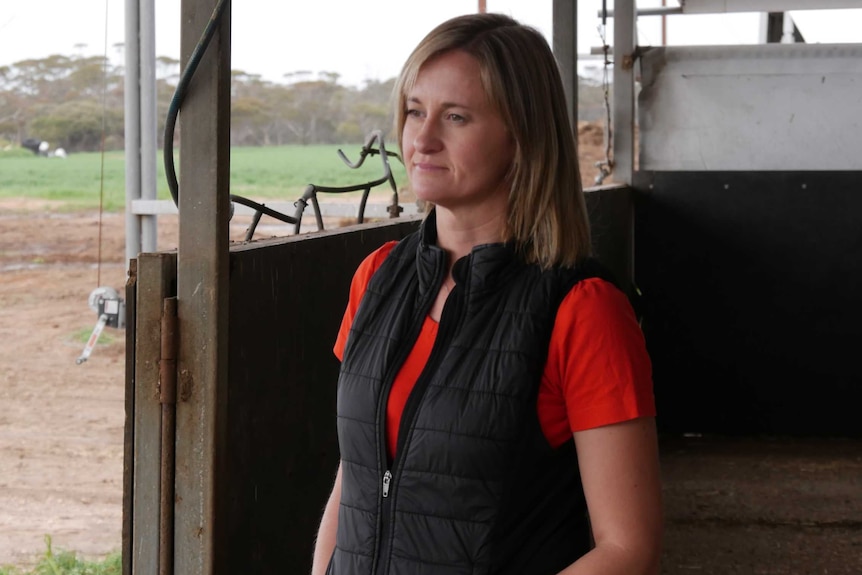 Bethany looking off in to the distance while inside a pig shed.