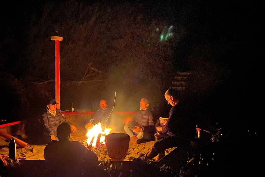 a group sitting around a fire 