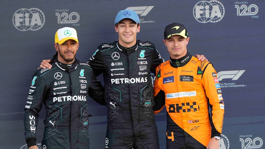 George Russell, Lewis Hamilton and Lando Norris stand together