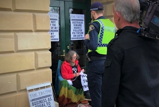 Sitting woman being spoken to by police.