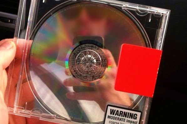 A CD in its case with a red sticker attached to the side