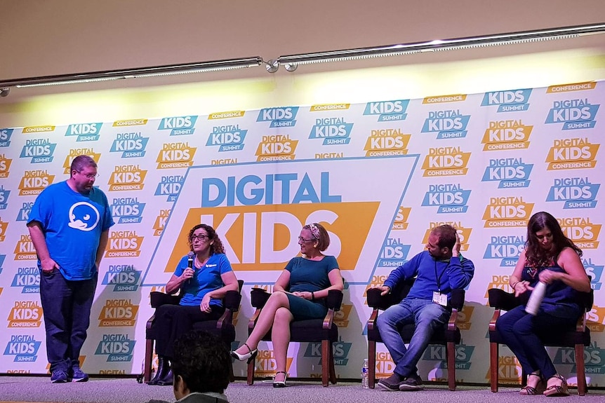 Anne-Marie Walton, seated with microphone, speaks on stage as part of a panel at the Digital Kids Summit in Austin, Texas.