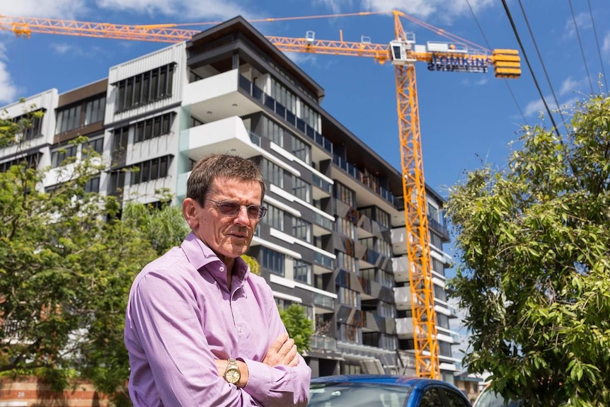 Brisbane City Council Opposition Leader Peter Cumming stands in front of a building under construction in Toowong.