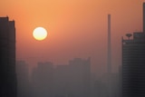A layer of pollution hovers over Beijing as the sun rises.