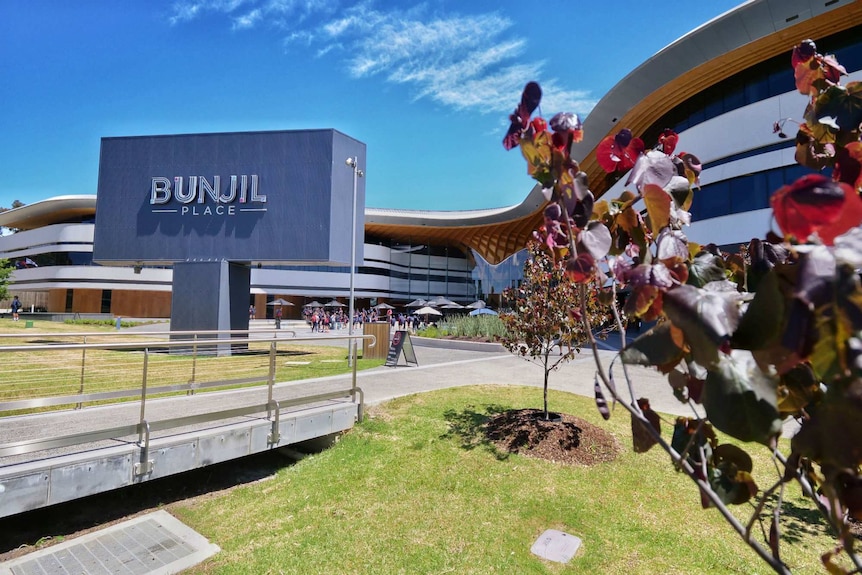 A sign for Bunjil Place is shown in front of a large multi-storey modern building.