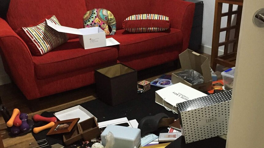 Boxes and papers strewn on a loungeroom floor after it has been ransacked by theives.