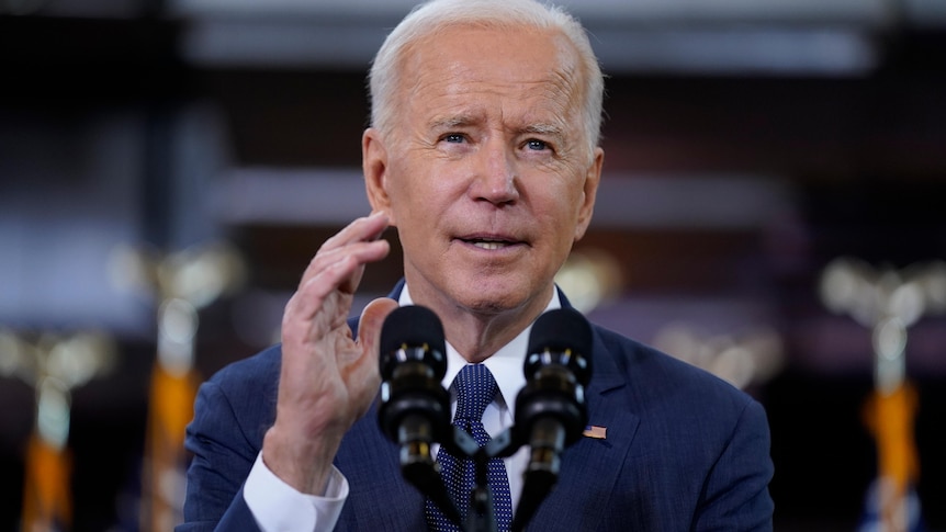 Joe Biden gestures as he speaks at a lectern