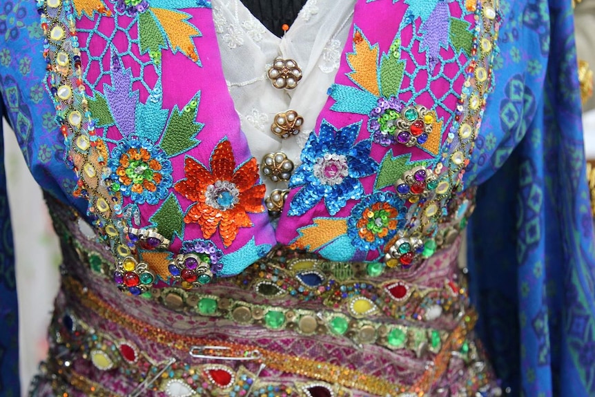 Heavily beaded, colourful dress close up