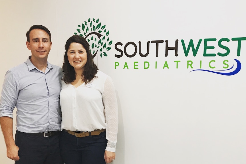 Man and woman standing next to a sign that reads South West Paediatrics.