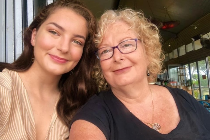 A mother and daughter smiling