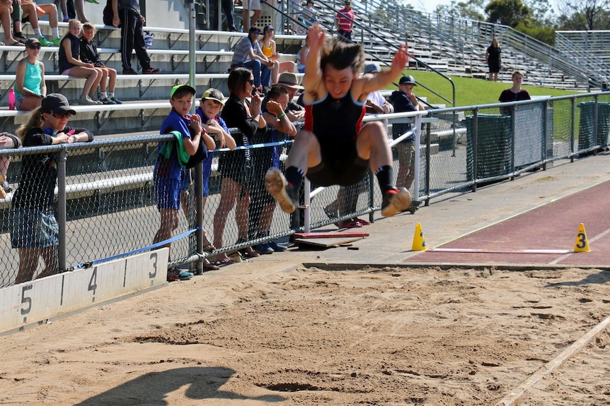 Tasmanian athlete Jack Hale lands after long jump