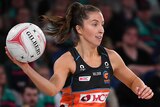 A Giants Super Netball player prepares to pass the ball with her right hand against the Melbourne Vixens.