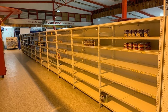 Shelves in a hall only have a few items on them