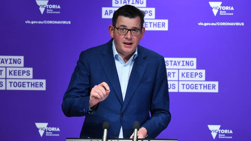 Daniel Andrews addresses the media from a lectern in front of a purple background carrying the Victorian Government logo.