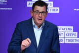 Daniel Andrews addresses the media from a lectern in front of a purple background carrying the Victorian Government logo.