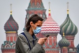 A man on his mobile phone in central Moscow with a colourful cathedral in the background