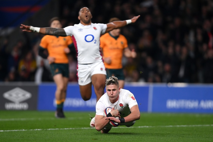 Freddie Steward dives with the ball under his right arm as Manu Tuilagi runs behind him with his arms stretched wide