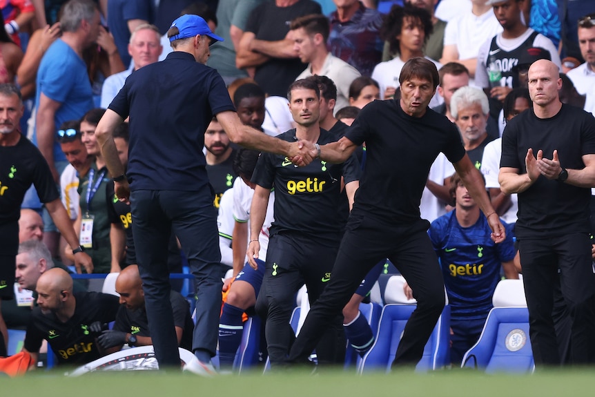 Tottenham coach Antonio Conte tries to pull away from Chelsea manager Thomas Tuchel's handshake.