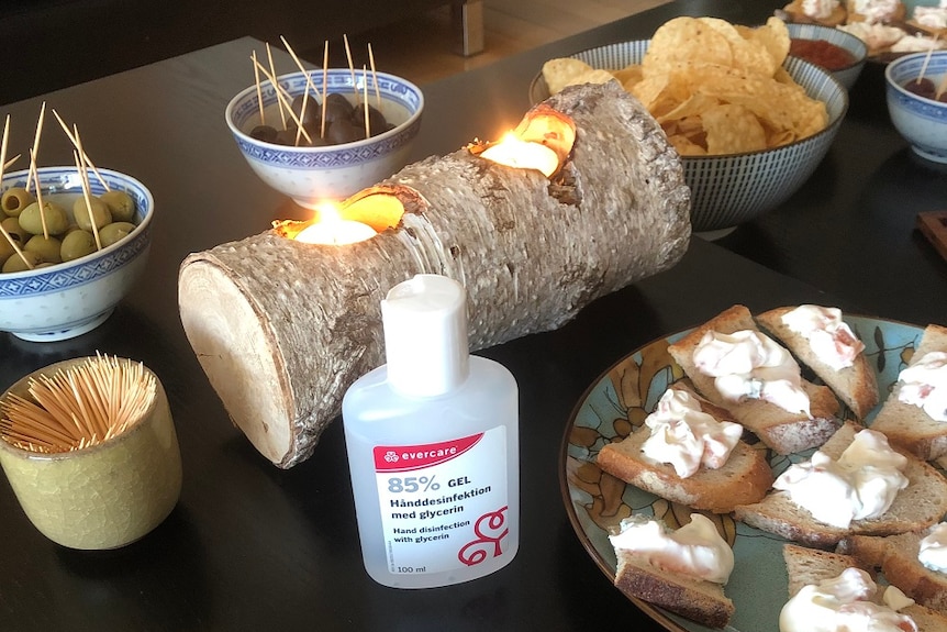 Some treats on a table next to some hand sanitiser