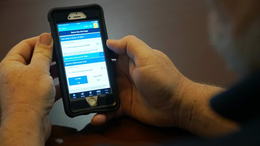 A man's hands holding a mobile phone.