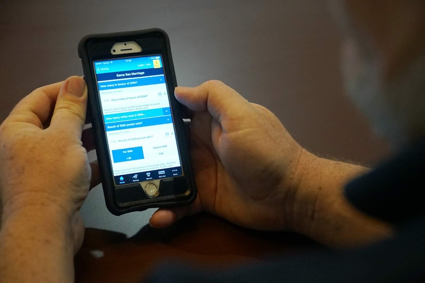 A man's hands holding a mobile phone.