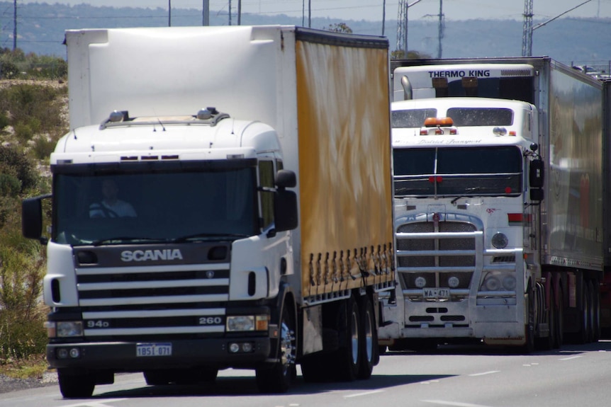 Two trucks travelling along Roe Highway.