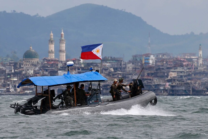 Philippine Navy commandos aboard a gunboat patrol the periphery of Lake Lanao near Marawi.