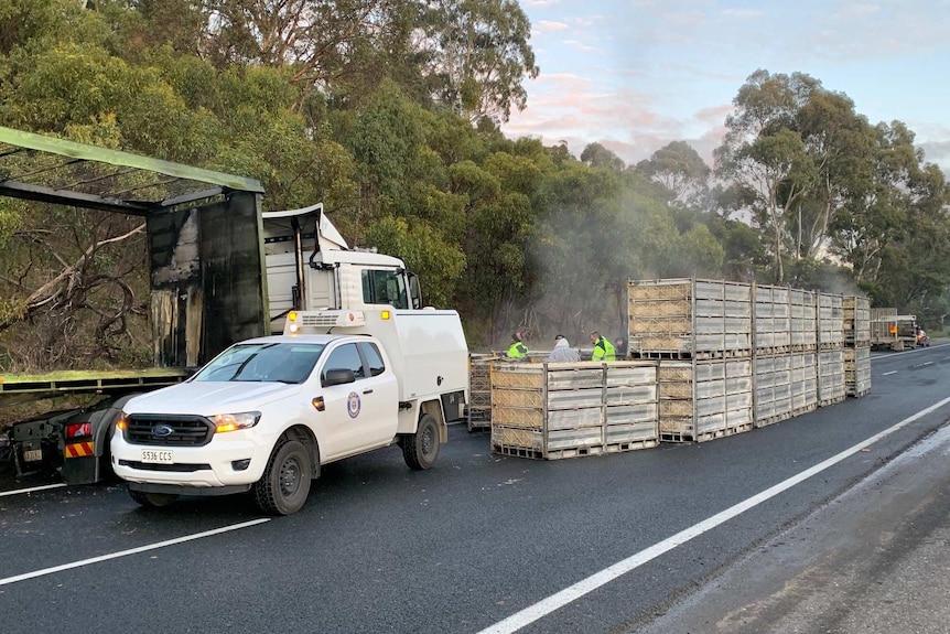 Wooden crates next to a truck on a road