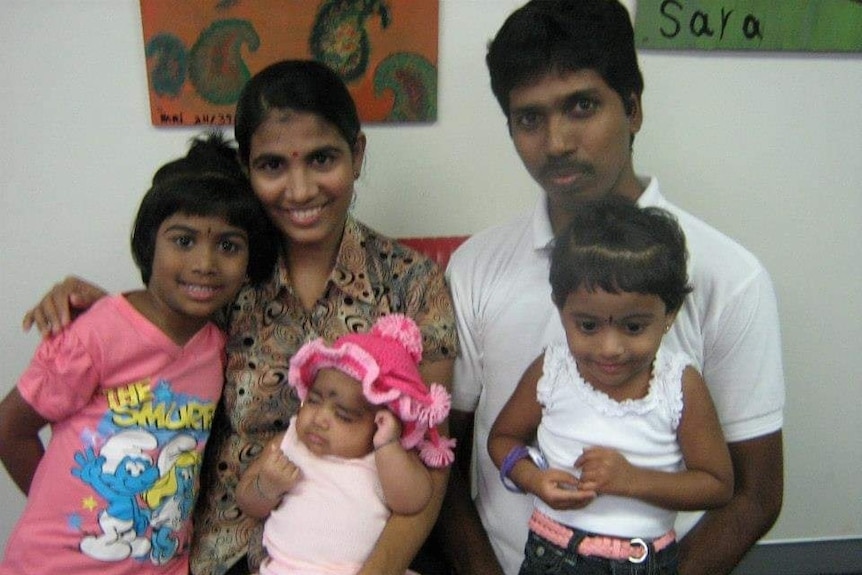 A man and woman with three young girls. 
