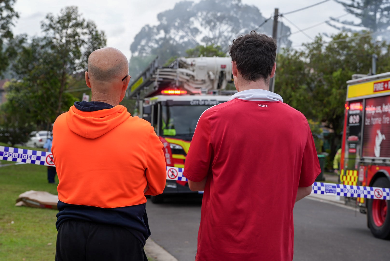 Two men staring at a fire truck.