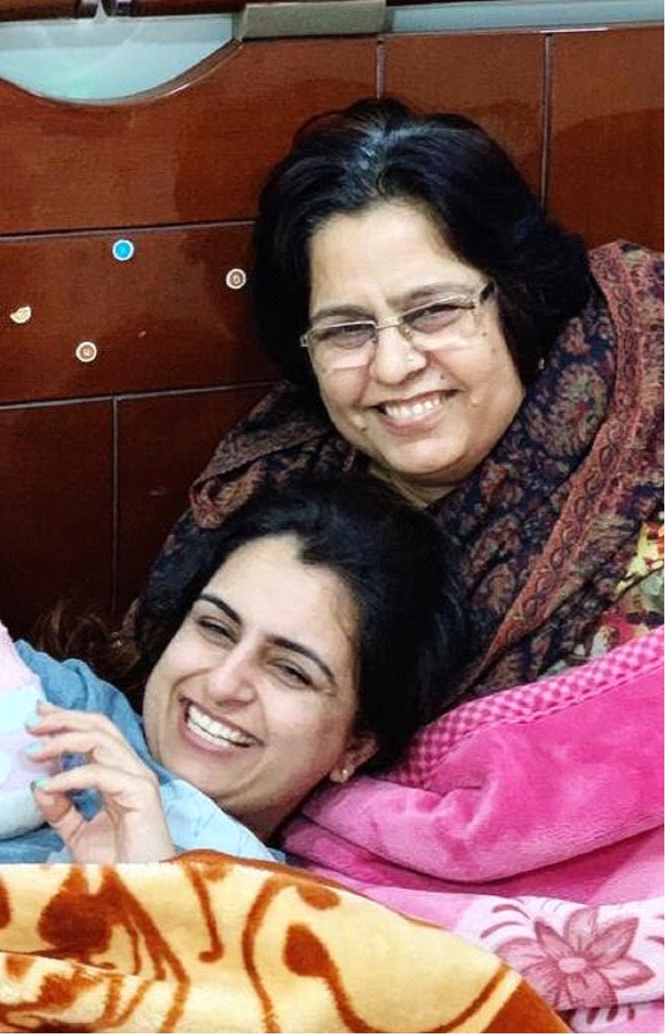 Two women laugh as they embrace each other