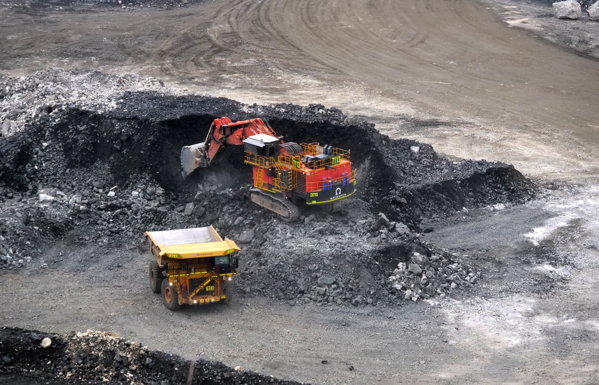 Uma escavadeira extrai uma pilha de minério de lítio.