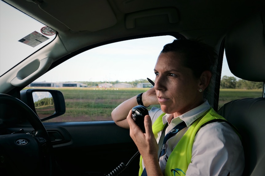 Woman in a car talking on a CB radio. 