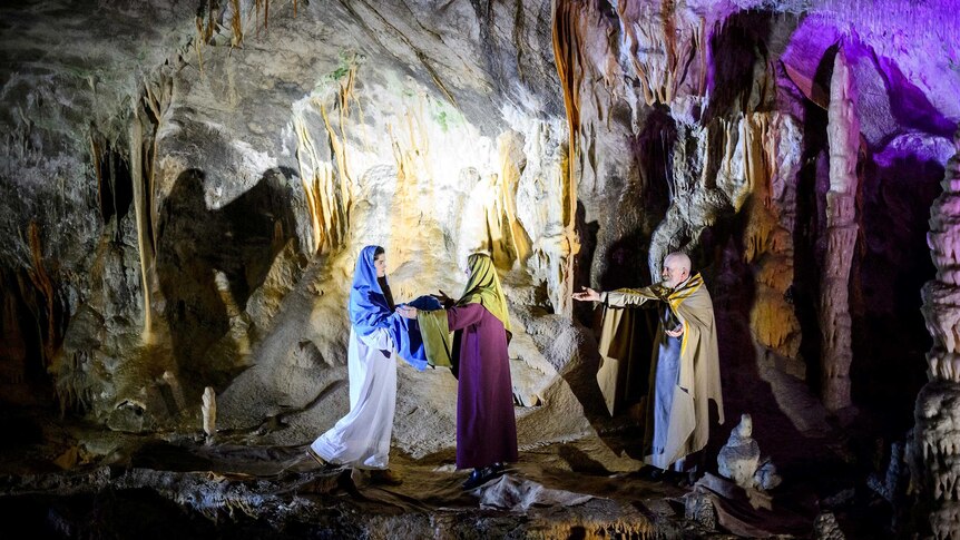 Amateur actors perform the nativity scene in Postojna Cave, with stalagmites hanging from the cave ceiling.