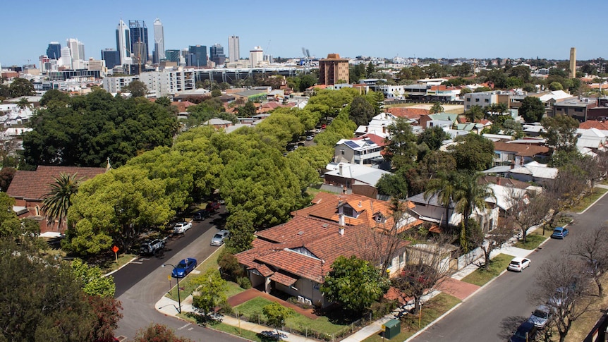 A wide aerial shot of houses close to Perth's CBD with the city in the background.