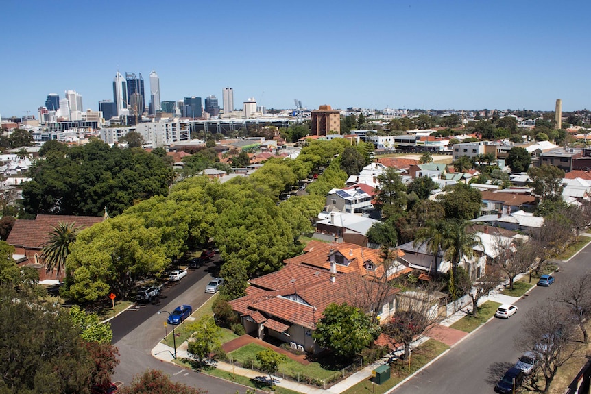 A wide aerial shot of houses close to Perth's CBD with the city in the background.