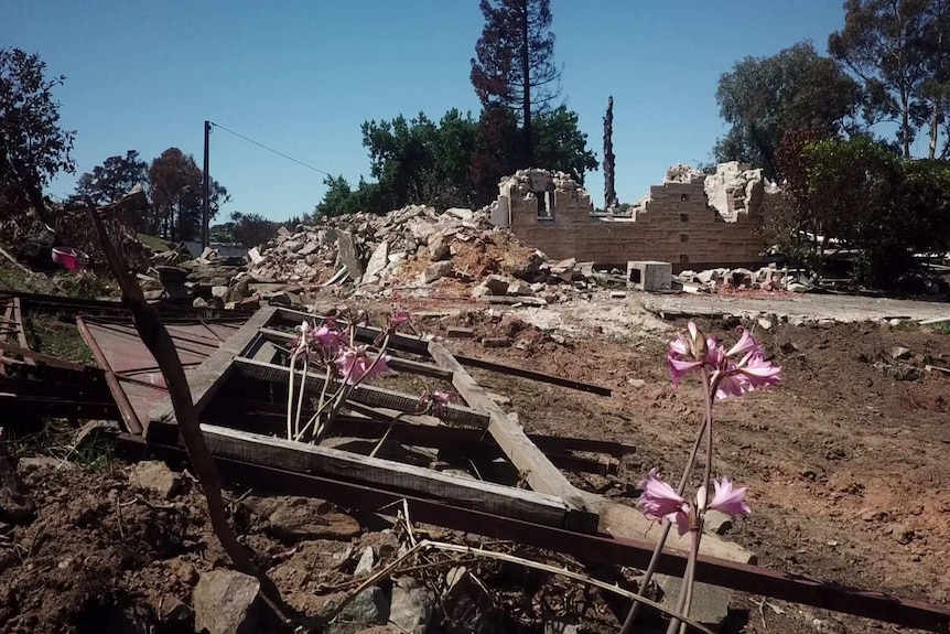 Adam Weinert's destroyed house with walls partially standing and piles of sandstone