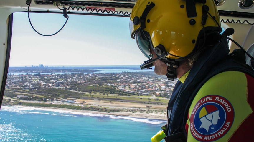 Surf Life Saving  rescue crewman Scott Hardstaff looks down at the water during a patrol of the Perth coastline.