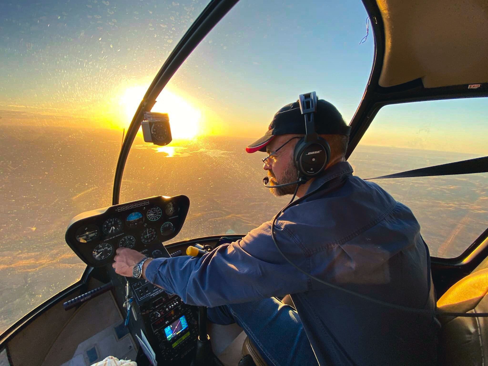 A man in a helicopter over land